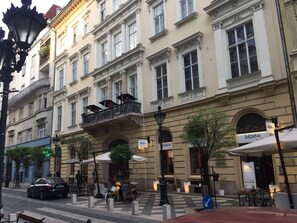 A historic building with multiple balconies, outdoor seating, and a restaurant named 'Gustolato'. - Pelicanstay next to Budapest Basillica (Budapest)