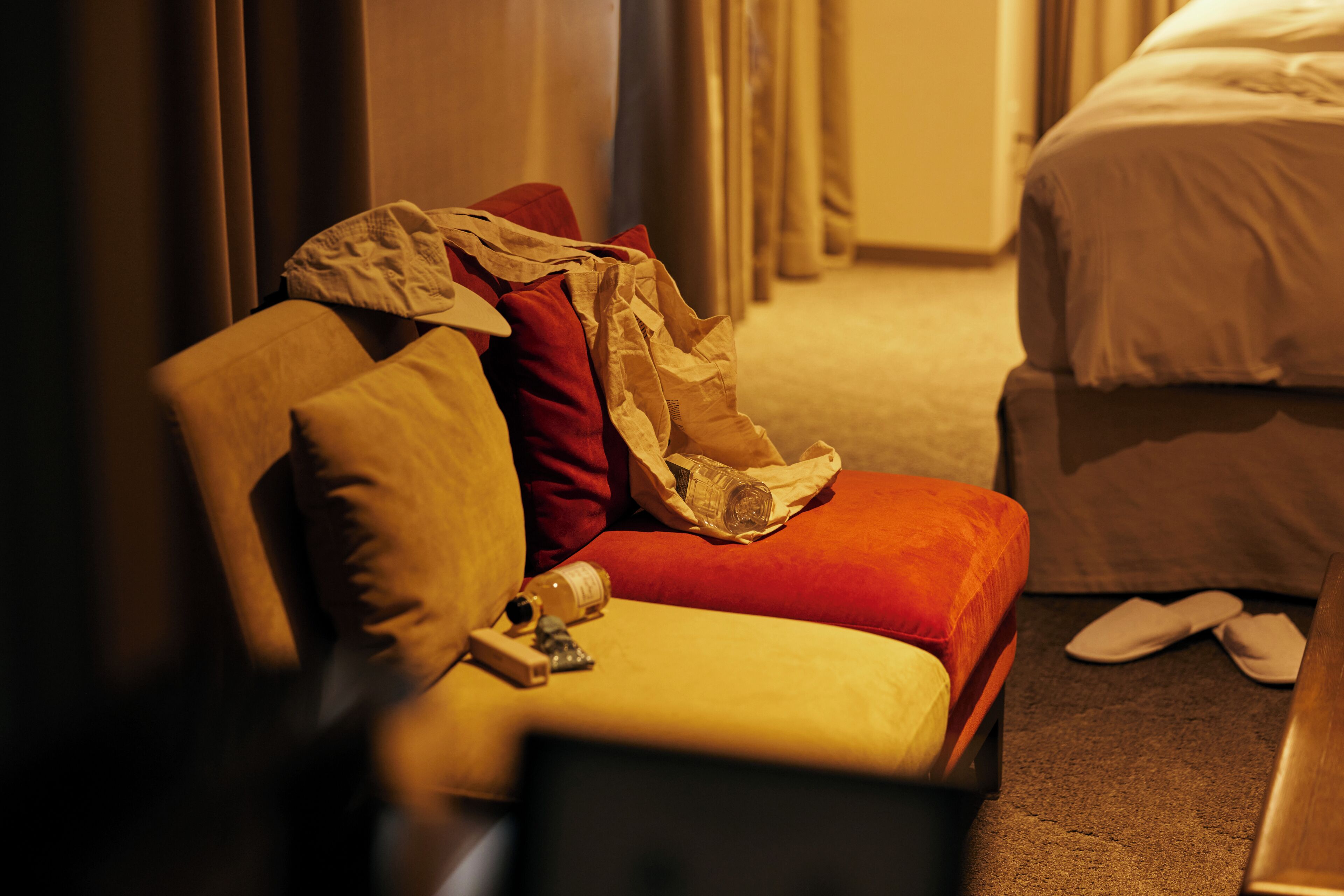 A hotel room with a bed, a chair, and a small table.