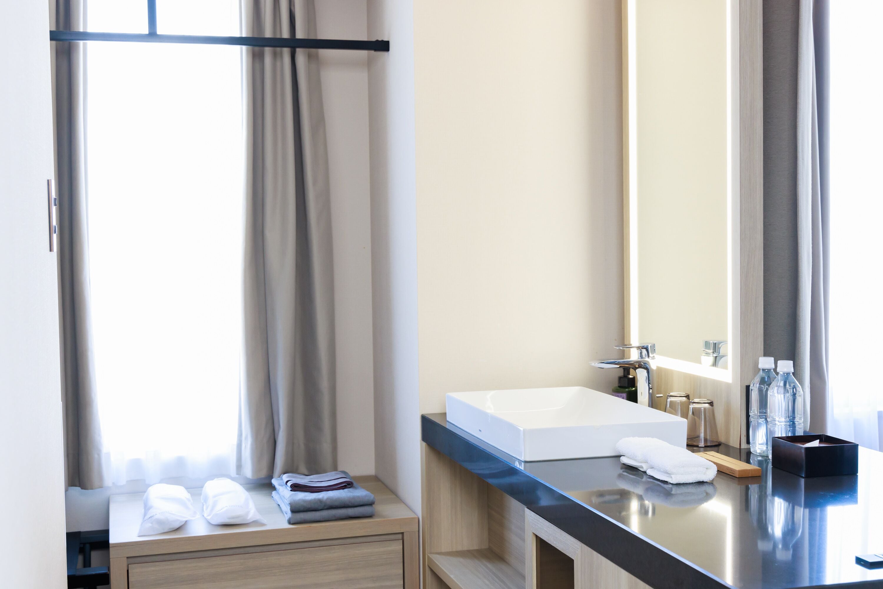 Un baño moderno con un espejo grande, un lavamanos blanco y un mueble de tocador de madera.