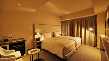 Ein Hotelzimmer mit einem großen Bett, einem Schreibtisch mit Stuhl, einem kleinen runden Tisch und einem Fernseher.