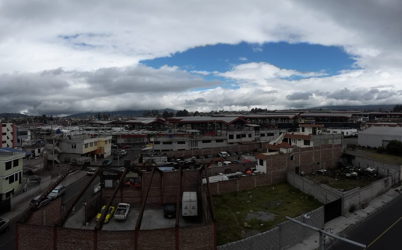 Vista de un paisaje urbano con varios edificios, calles y un estacionamiento.