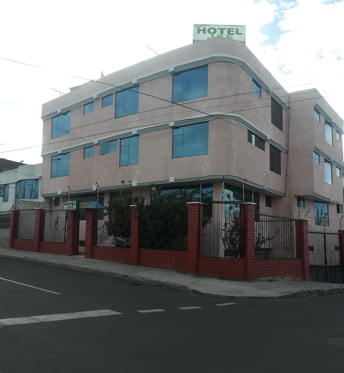 A multi-story hotel with a flat facade, large windows, and a gated entrance.