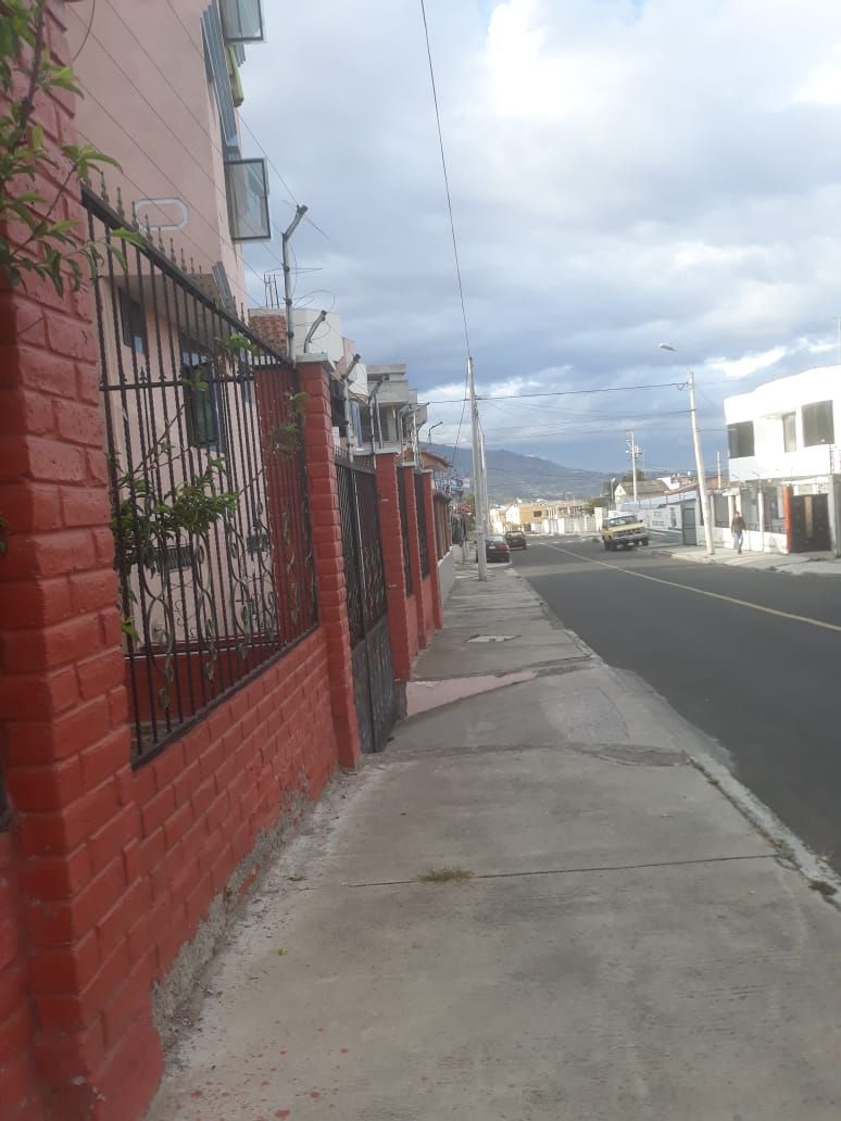 A street with a red brick building, a sidewalk, and a road.
