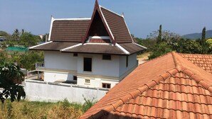 Una casa de dos pisos con techo inclinado y un pequeño balcón.