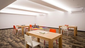 A conference room with a high ceiling, wooden tables, and chairs, and a colorful carpet. - Xianghe Hotel (Mingjian)