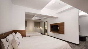 A modern hotel room with a large bed, a TV mounted on the wall, and a small seating area. - Xianghe Hotel (Mingjian)
