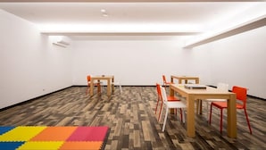 A spacious room with a high ceiling, wooden flooring, and a colorful foam mat at the entrance. - Xianghe Hotel (Mingjian)