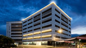 A multi-story parking garage with illuminated entryways and a modern design. - Xianghe Hotel (Mingjian)