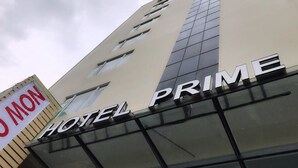 Ein Hotel namens HOTEL PRIME mit moderner Fassade und großen Fenstern.