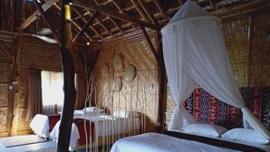 A room with a bed, a hanging chair, and a canopy bed. - Mario Hotel and Cafe (Tambolaka)