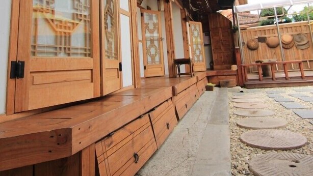 A traditional Japanese building with wooden sliding doors and a covered walkway. - Happy Maru (Jeonju)