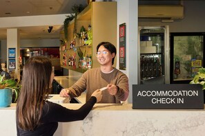 A hotel reception area with a sign for 'ACCOMMODATION CHECK IN'. - Oasis on Beamish Hotel (Campsie)