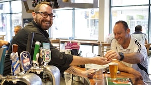 Zona de bar con múltiples grifos de cerveza, una jarra de cerveza y un panel de menú.