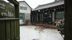 A traditional building with a snow-covered entrance and a sign indicating the address 86.2. - Eunhaengro 86.2 (Jeonju)