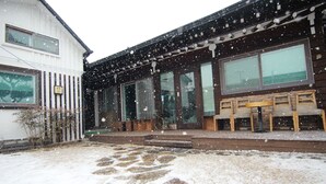 A building with large windows and a covered outdoor seating area. - Eunhaengro 86.2 (Jeonju)