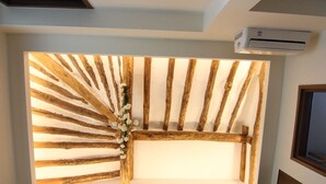 A room with a slatted ceiling design, an air conditioning unit, and a framed picture on the wall. - Eunhaengro 86.2 (Jeonju)