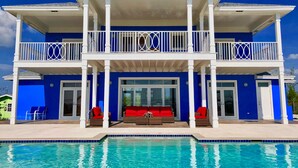 A two-story house with a pool in front.