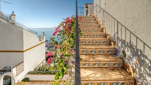 A staircase with ornate tiles leading to a balcony overlooking a coastal view. - Lovely apartment in villa for 4 people with WIFI, pool, A/C, TV and terrace (Roses)