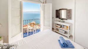 A bedroom with a large bed, a bathroom vanity, and a view of the sea. - Lovely apartment in villa for 4 people with WIFI, pool, A/C, TV and terrace (Roses)