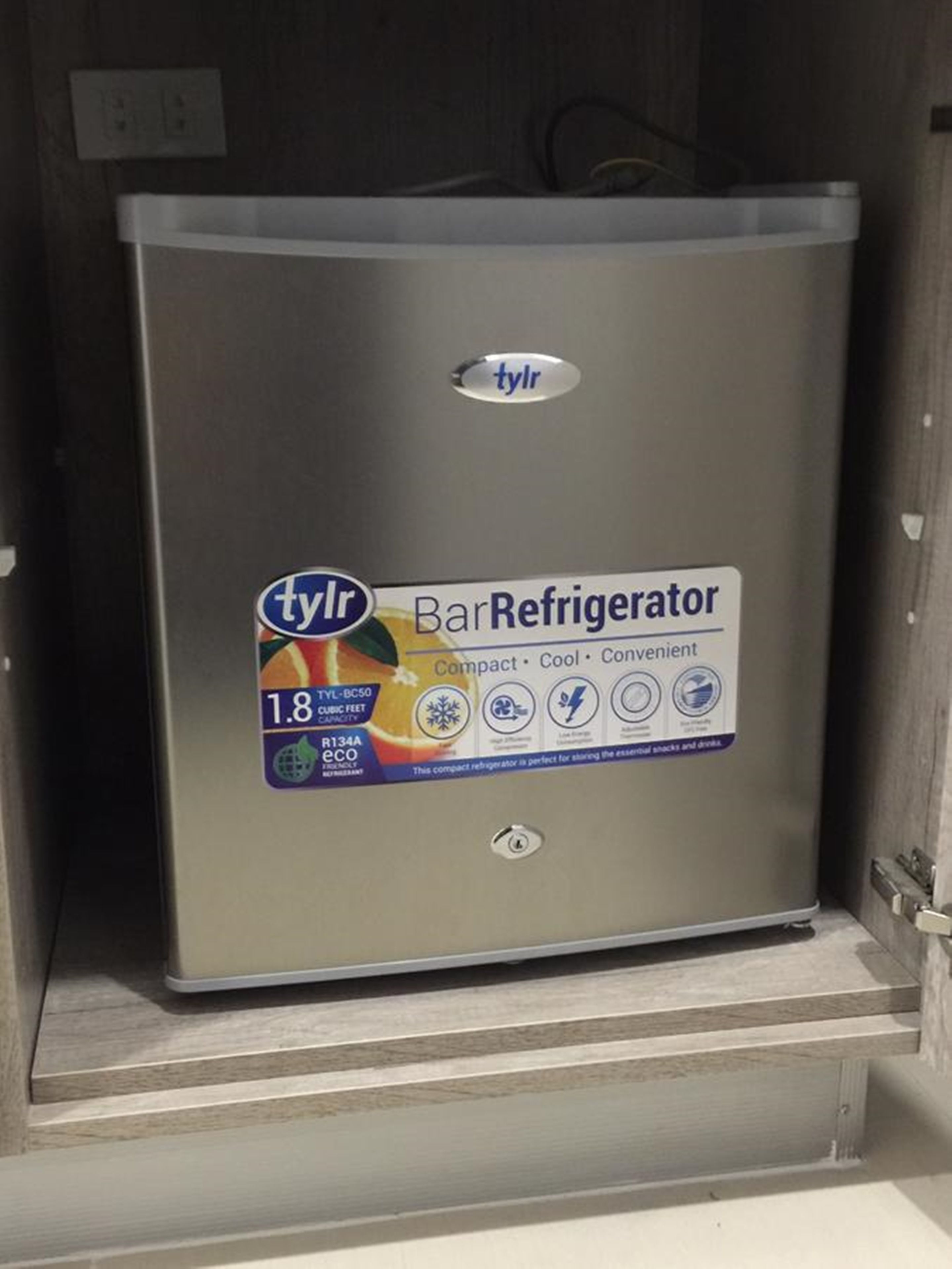 A compact bar refrigerator with a capacity of 1.8 cubic feet, labeled as 'tylr Bar Refrigerator' and described as 'Compact, Cool, Convenient'.