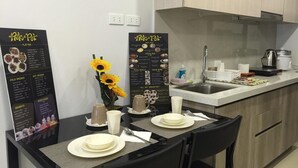 A modern kitchen with a dining table set for two, a coffee maker, and a menu board. - 5F18 Your home baguio (Baguio)