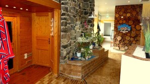 A wooden interior with a stone wall, a reception desk, and a staircase. - DeLuchs bed linen bookable - DeLuchs (Bad Harzburg)