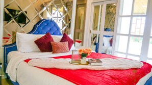 A bedroom with a large bed, multiple pillows, a vase with flowers, and a book. - Exquisite Pool Villa C (Pattaya)