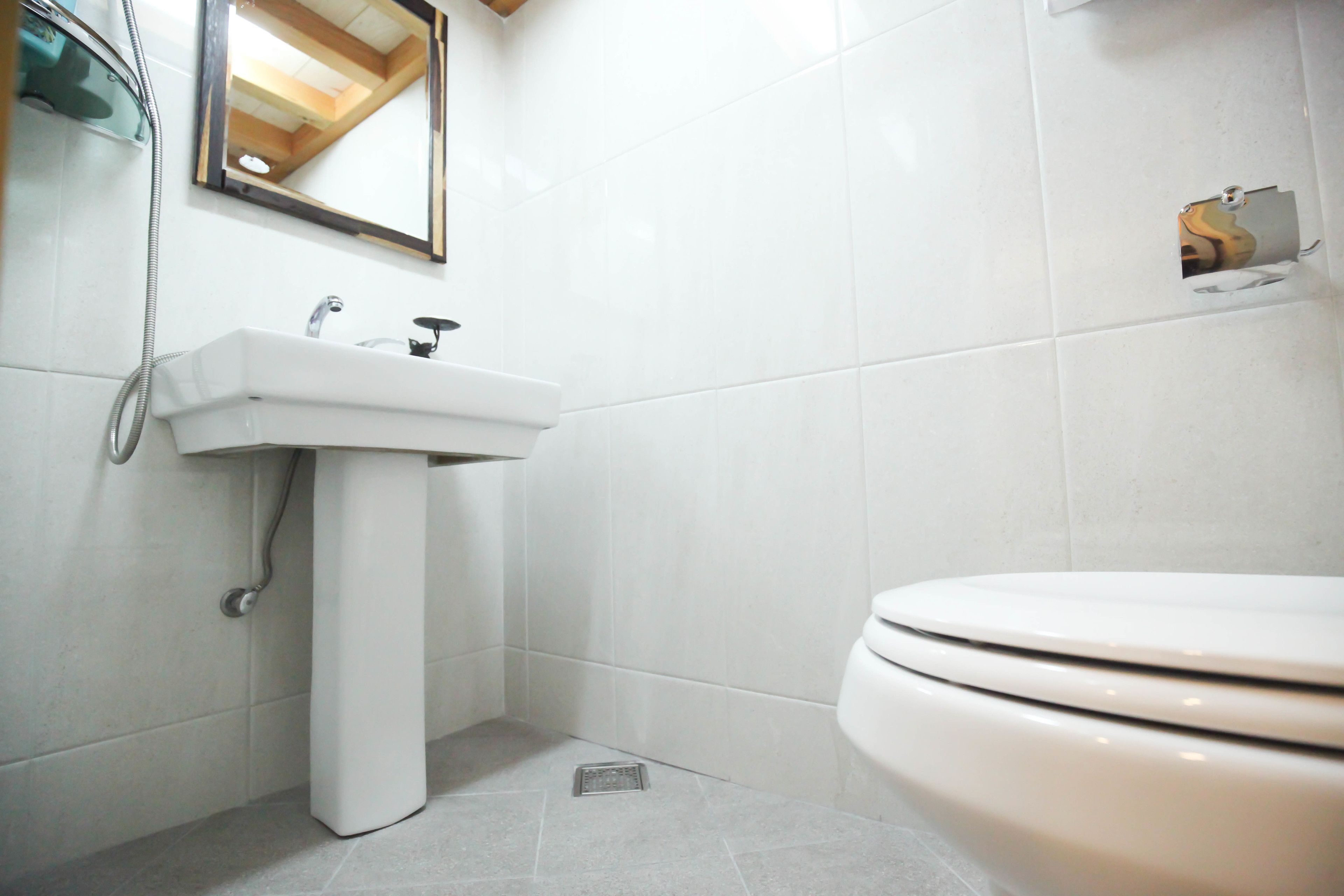 Een badkamer met een witte wastafel, een spiegel en een toilet.