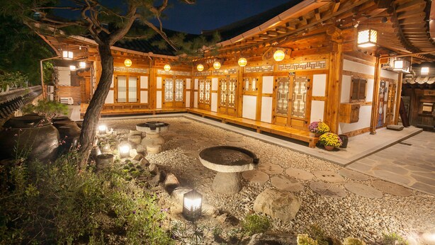 A traditional Japanese building with wooden architecture, a stone courtyard, and lanterns. - Samlockhon (Jeonju)
