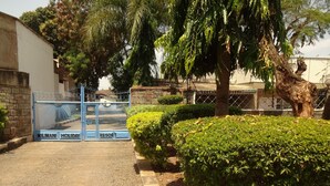 A gated entrance to a property labeled "Milimani Holiday Resort" with a paved driveway and well-maintained greenery. - Milimani Holiday Resort (Kisumu)