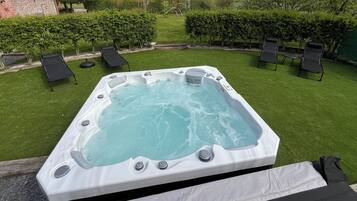 Relax in the backyard with a central hot tub and lounge chairs.