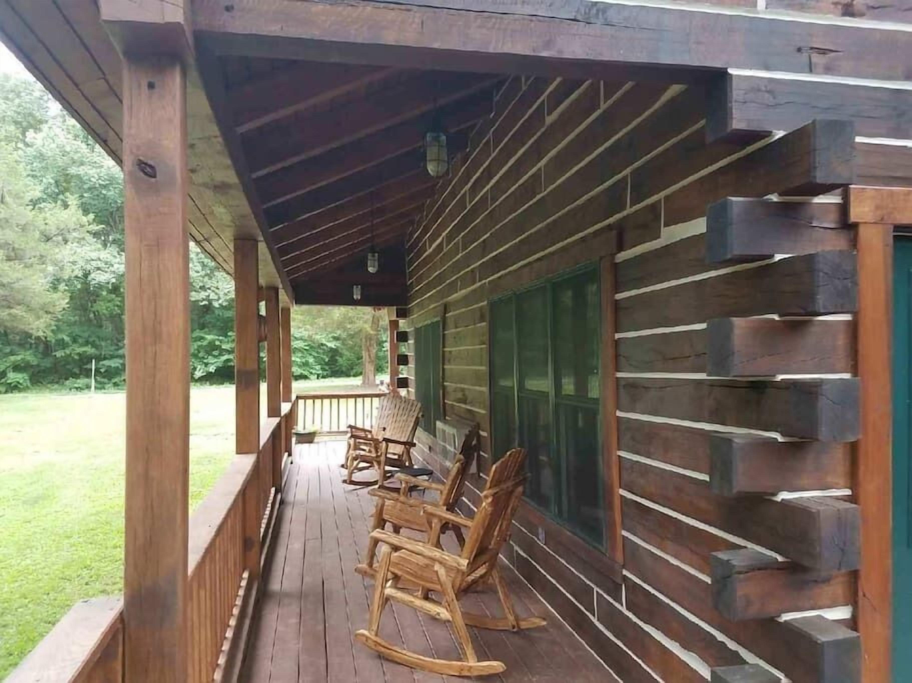 A wooden deck with rocking chairs and a covered porch area.