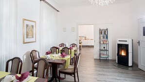 En matplats med ett bord dukat för fyra personer, en öppen spis och en bokhylla.