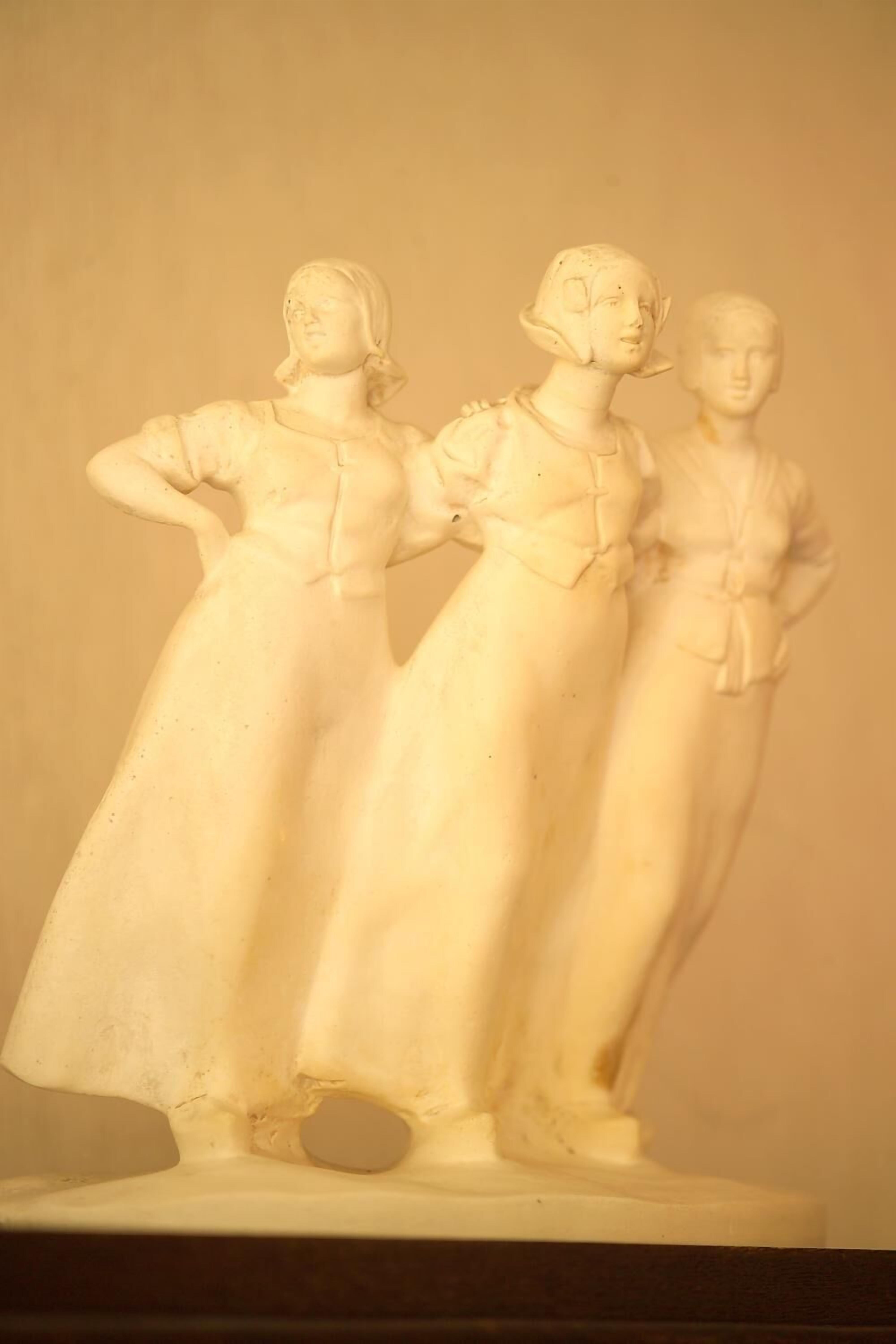 A white sculpture of three figures.