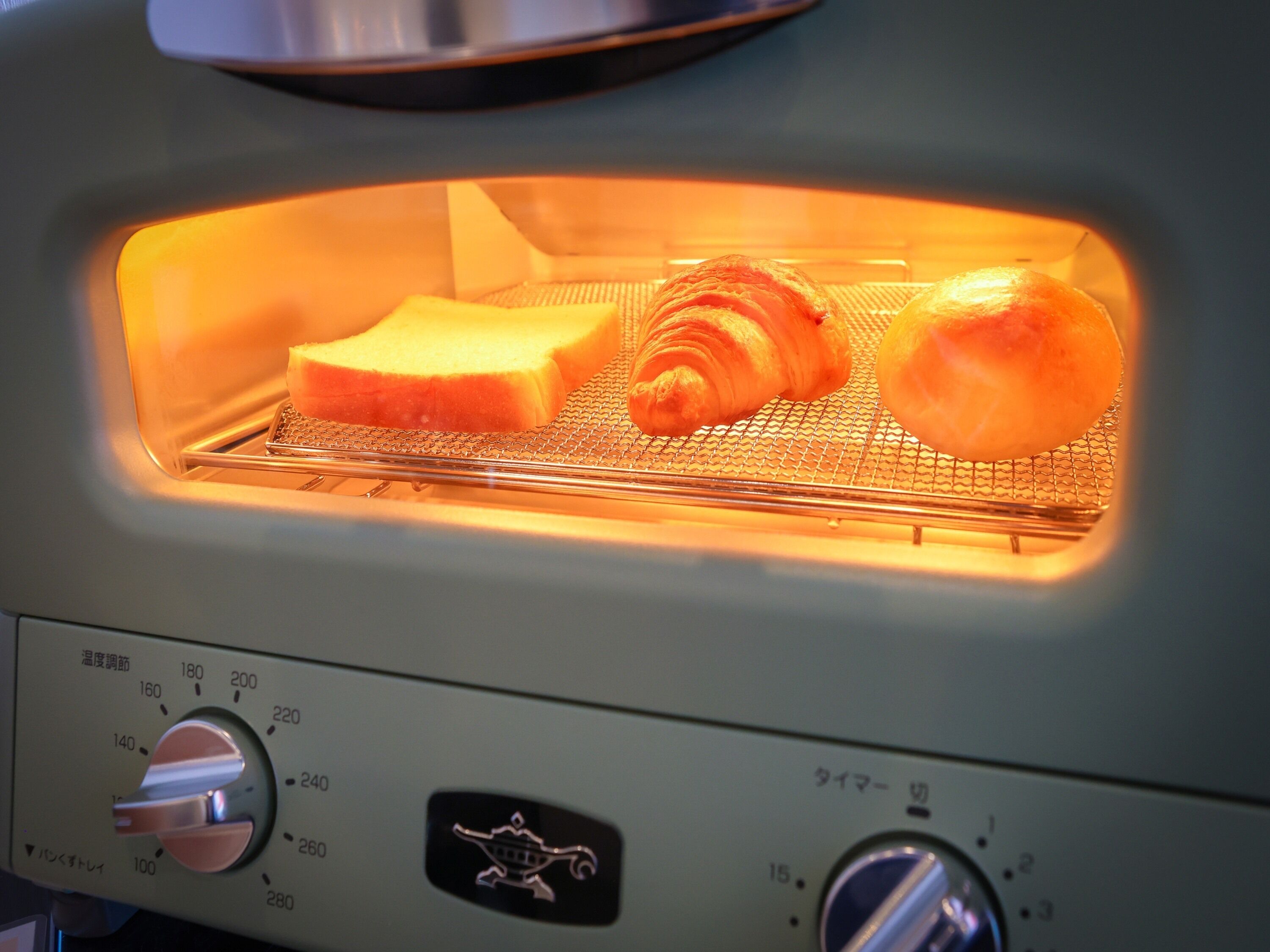 Un horno tostador con panel de control de temperatura digital y una rejilla metálica en su interior.
