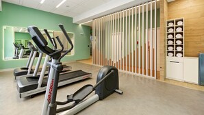 A gym with treadmills, a stationary bike, and a rowing machine. There is a wooden wall with shelves and a mirror. - Holiday Inn Express Lima San Isidro by IHG (Lima)