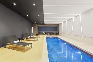 Una piscina techada, sillones reclinables de piscina