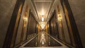 A long, polished hallway with reflective floors and walls, leading to a bright, well-lit end. - Homeland International Hotel (Huizhou)