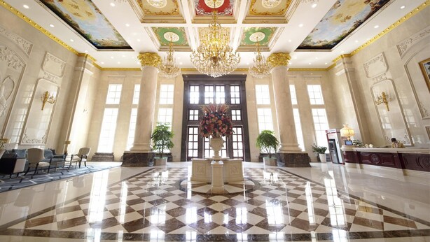 A grand lobby with a checkered floor, ornate chandeliers, and a large floral centerpiece. - Homeland International Hotel (Huizhou)