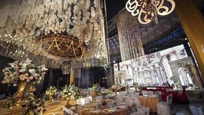 A grand banquet hall with ornate chandeliers, floral centerpieces, and a stage with elaborate decorations. - Homeland International Hotel (Huizhou)