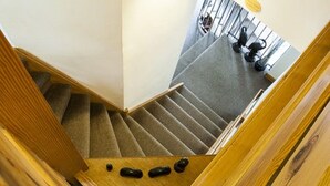 Un escalier en bois avec des marches recouvertes de moquette et une main courante.