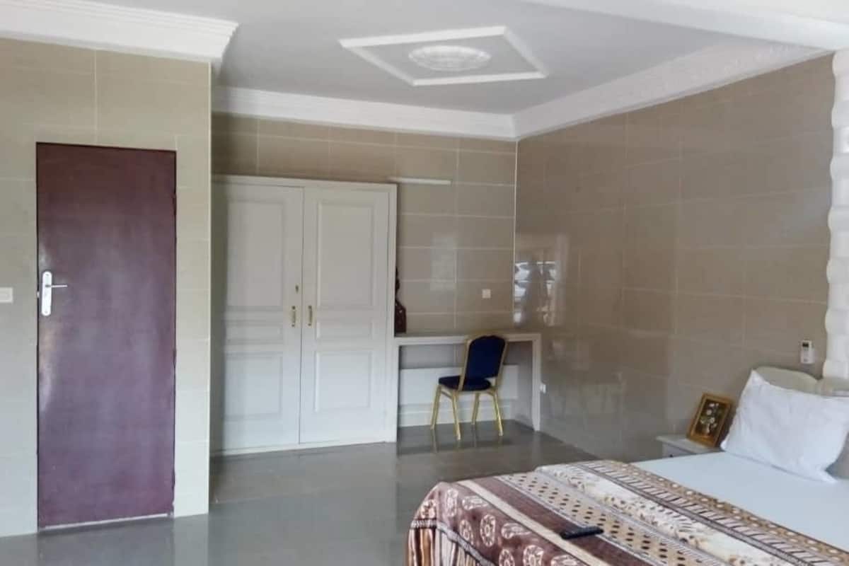 A bedroom with a bed, a desk, and a chair.