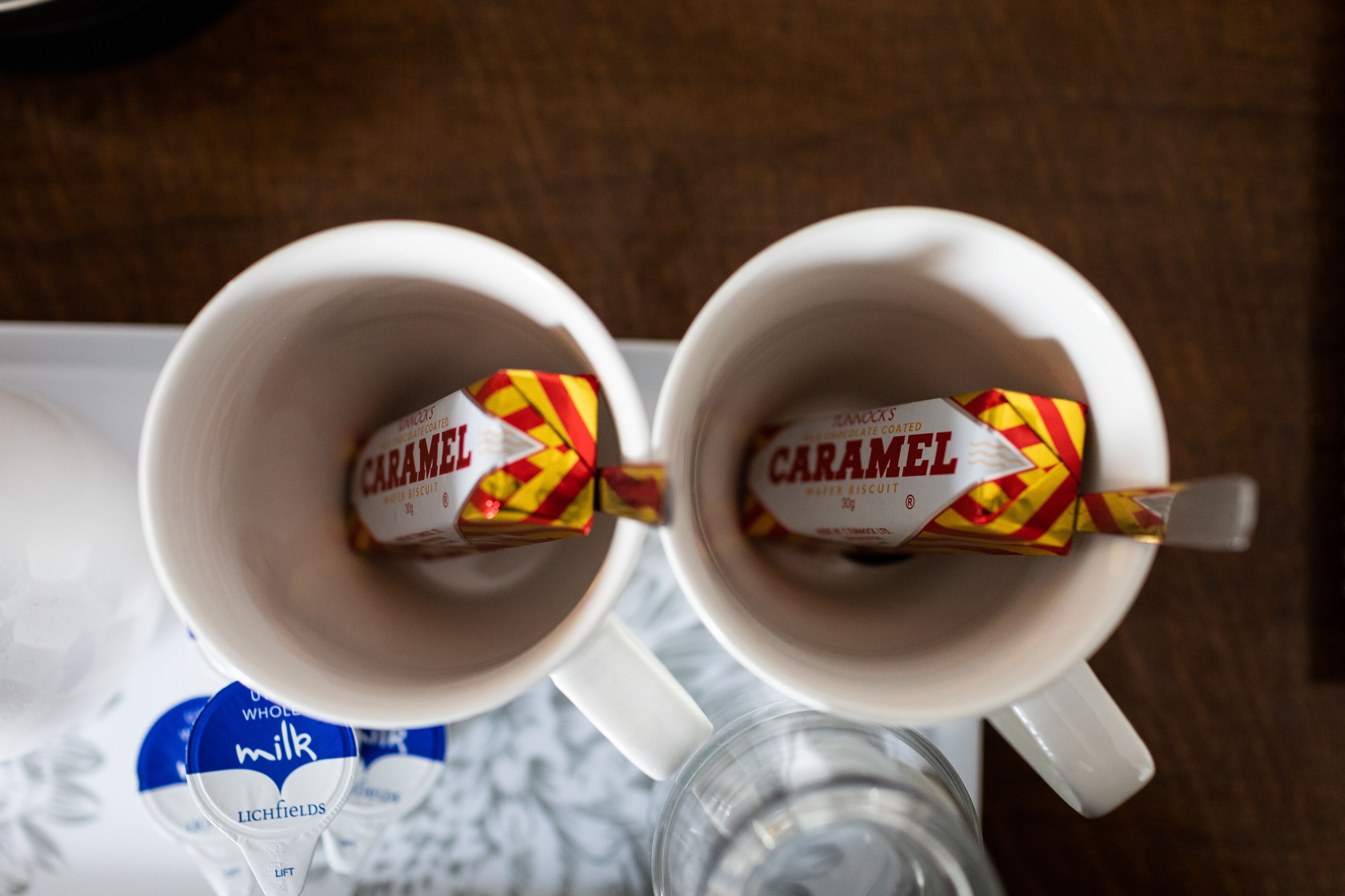 Two white mugs with a caramel-colored biscuit inside.