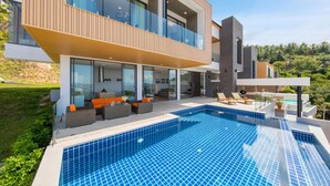 A modern two-story house with a swimming pool, outdoor seating, and a view of the surrounding greenery. - Samui Villa Bebe (Koh Samui)