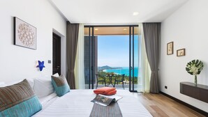 A hotel room with a large bed, a view of the sea, and a balcony with a table and chairs. - Samui Villa Bebe (Koh Samui)