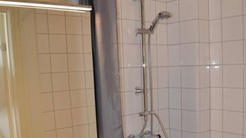 Ein Badezimmer mit Dusche, Waschbecken und Spiegel.