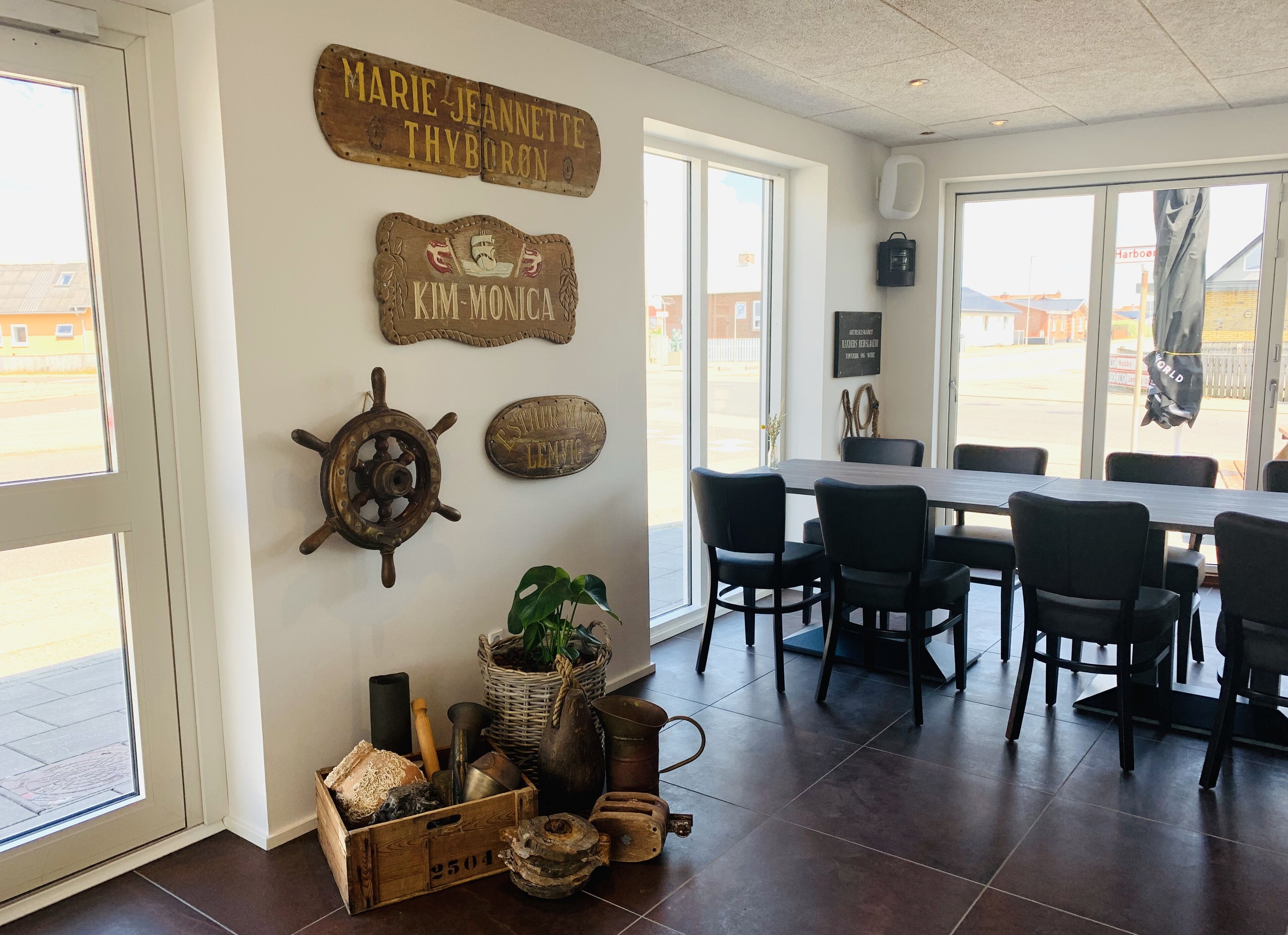 Un comedor con una mesa grande y sillas, decoración rústica en las paredes y vistas por las ventanas.