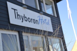 A sign for Thyborean Hotel with a clear view of the building's exterior. - Thyborøn Hotel (Thyborøn)