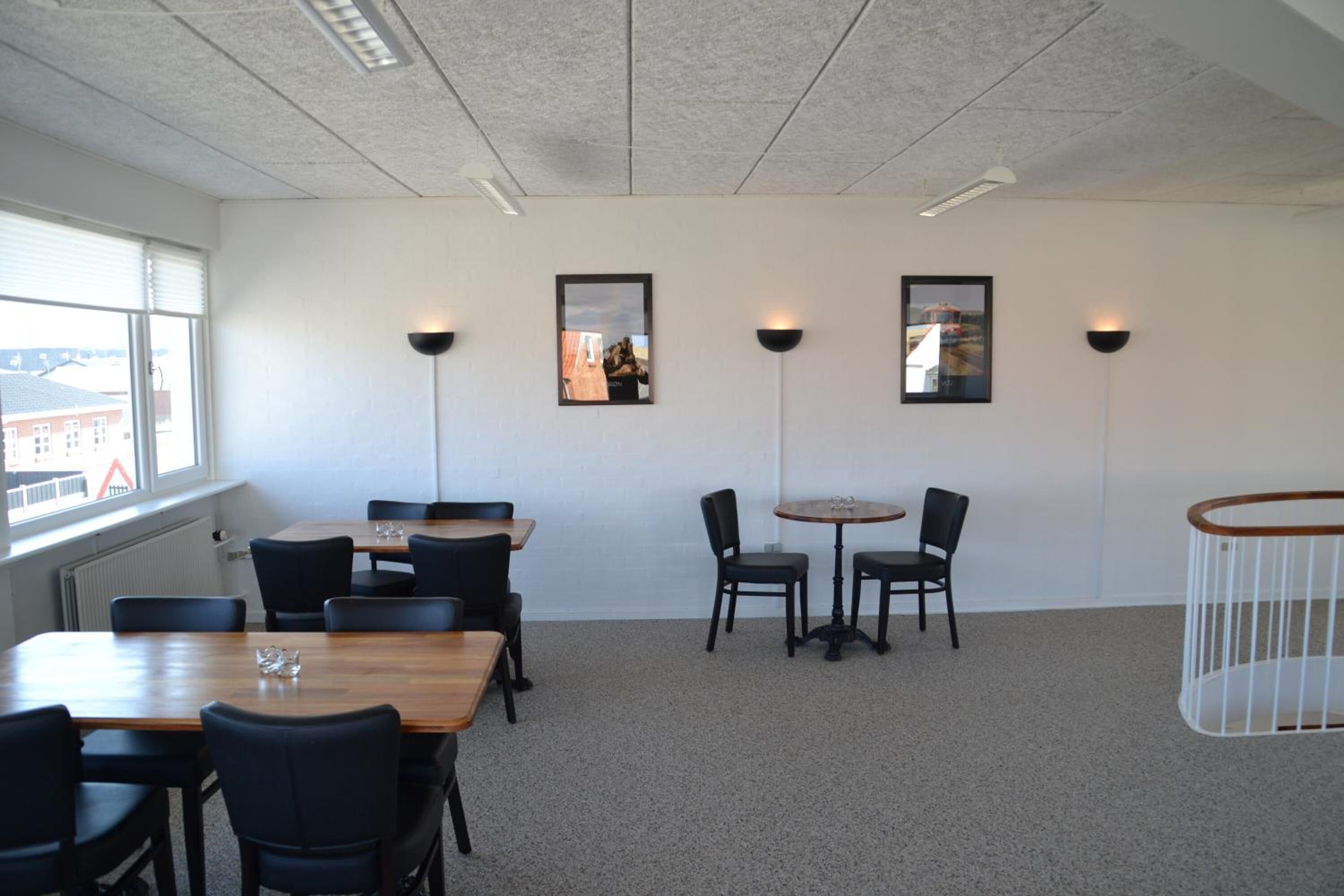 A conference room with a wooden table, black chairs, and a white crib.
