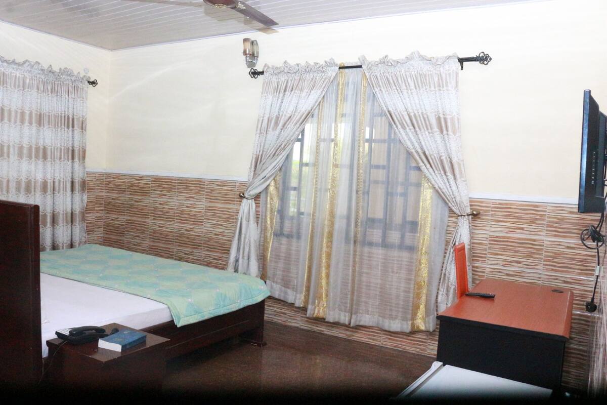 A room with two beds, a desk, and a television.